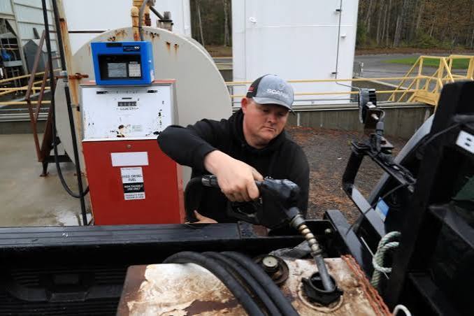Worker fueling a truck at a diesel pump