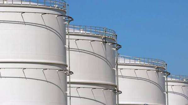 Rows of white diesel storage tanks against a blue sky
